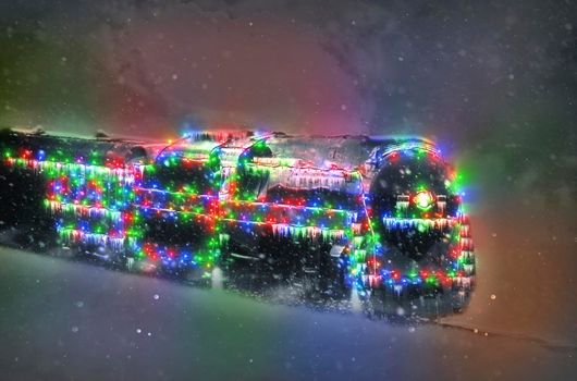 A Restored Steam Engine With Christmas Lights on it in a Snow Storm