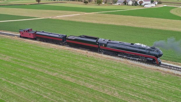 Aerial View of a Restored Antique Steam Locomotive Pulling a Caboose on a Sunny Fall Day