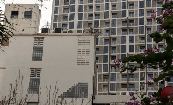 Architectural View of Overlapping old house buildings and modern condominium in bangkok, Thailand. Selective focus.