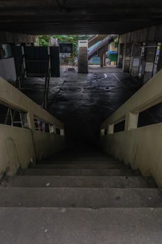 View from the top of the old cement stairs leading down to the community basketball court under the bridge. Focus and blur.