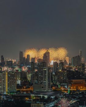 Colorful Firework with cityscape night light view of Bangkok skyline at twilight time. New Year celebration fireworks, Bangkok city,Thailand Fireworks light up to sky at Christmas & New Year festival with free space for text. No focus, specifically.