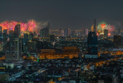 Colorful Firework with cityscape night light view of Bangkok skyline at twilight time. New Year celebration fireworks, Bangkok city,Thailand Fireworks light up to sky at Christmas & New Year festival with free space for text. No focus, specifically.