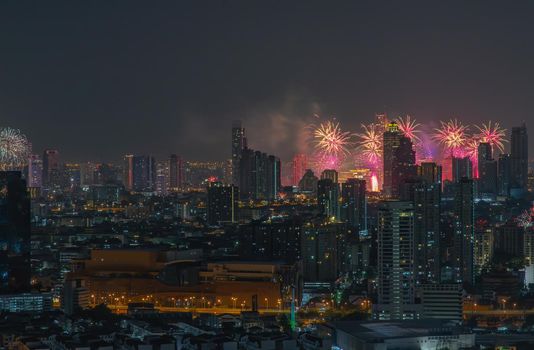 Colorful Firework with cityscape night light view of Bangkok skyline at twilight time. New Year celebration fireworks, Bangkok city,Thailand Fireworks light up to sky at Christmas & New Year festival with free space for text. No focus, specifically.