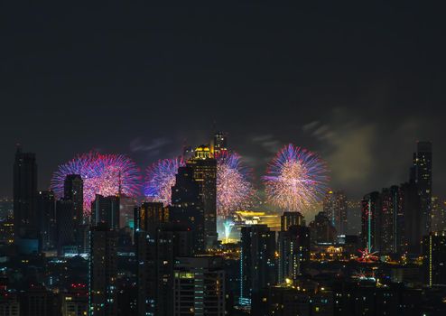 Colorful Firework with cityscape night light view of Bangkok skyline at twilight time. New Year celebration fireworks, Bangkok city,Thailand Fireworks light up to sky at Christmas & New Year festival with free space for text. No focus, specifically.