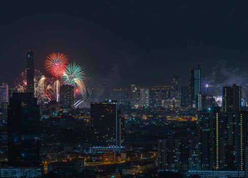 Colorful Firework with cityscape night light view of Bangkok skyline at twilight time. New Year celebration fireworks, Bangkok city,Thailand Fireworks light up to sky at Christmas & New Year festival with free space for text. No focus, specifically.
