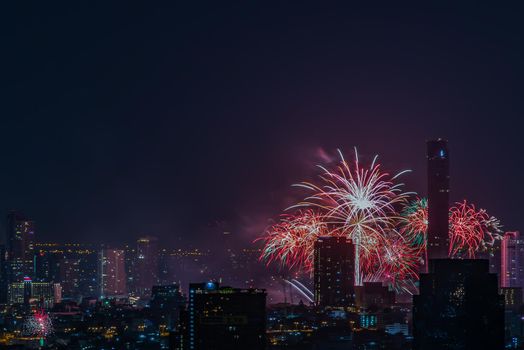 Colorful Firework with cityscape night light view of Bangkok skyline at twilight time. New Year celebration fireworks, Bangkok city,Thailand Fireworks light up to sky at Christmas & New Year festival with free space for text. No focus, specifically.