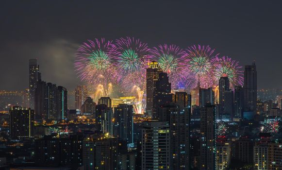 Colorful Firework with cityscape night light view of Bangkok skyline at twilight time. New Year celebration fireworks, Bangkok city,Thailand Fireworks light up to sky at Christmas & New Year festival with free space for text.