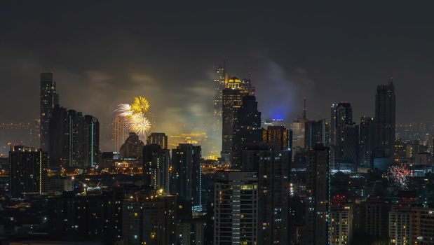 Colorful Firework with cityscape night light view of Bangkok skyline at twilight time. New Year celebration fireworks, Bangkok city,Thailand Fireworks light up to sky at Christmas & New Year festival with free space for text. No focus, specifically.