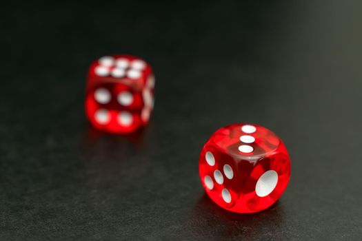 Red dice lie after the throw on the gaming table in the casino