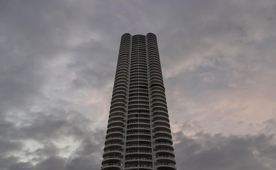 Bangkok, Thailand - 04 Jan 2021 : Low angle looking up at Condominium building with repeating structure and clouds background. Dark tone, No focus, specifically.