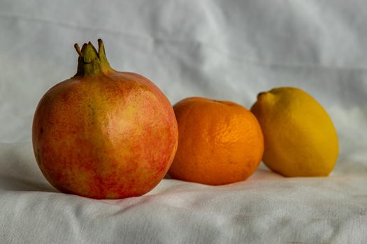 Fresh fruits with Pomegranate, Orange and Lemon on white background. Selective focus.