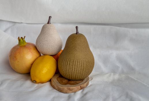 Two ceramics pear fruits and Fresh fruits on white background. Ceramic tableware, Home decor, Copy space.