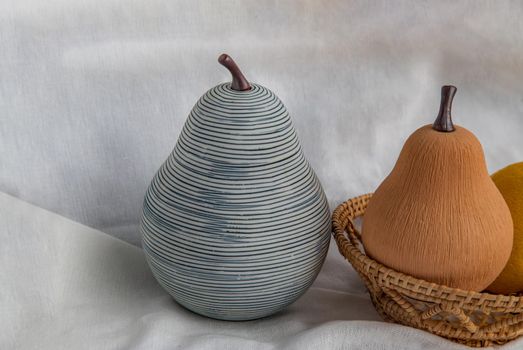 Two ceramics pear fruits on white background. Ceramic tableware, Home decor, Copy space.