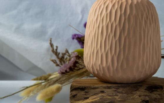 Close-up of Handmade Ceramic Vases and Dried flowers on wooden logs. Home decor, Space for text.