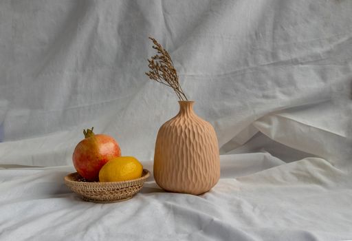 Dried flowers in Handmade Ceramic Vases and Fresh fruits on Wicker basket with white background. Home decor.
