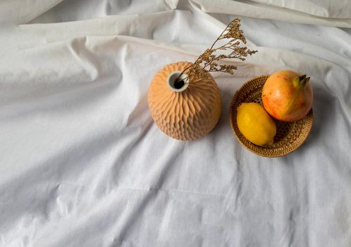 Dried flowers in Handmade Ceramic Vases and Fresh fruits on Wicker basket with white background. Home decor.