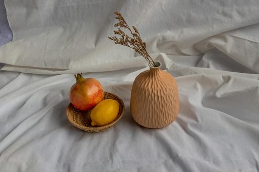 Dried flowers in Handmade Ceramic Vases and Fresh fruits on Wicker basket with white background. Home decor.