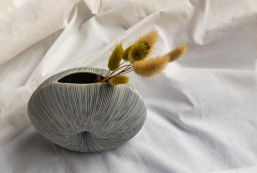 Dried flowers in Handmade Ceramic Vase on White background. Home decor, Space for text.