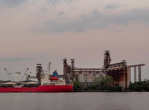 Bangkok, Thailand - 04 Jan 2021 : A cargo ship parked in front of The Fish Quarantine and inspection regional center at Bang Krachao t evening. Selective focus.