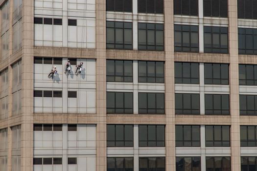 Group of workers cleaning windows service on high rise office building. Selective focus.