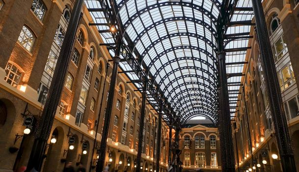 London, England - Apr 20, 2019 : Interior view of Hay's Galleria glass roof. Is a mixed use building in the London Borough of Southwark, featuring offices, restaurants, shops, and flats. No focus, specifically.