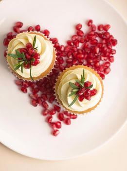 Valentines cupcakes with vanilla icing and a red heart.