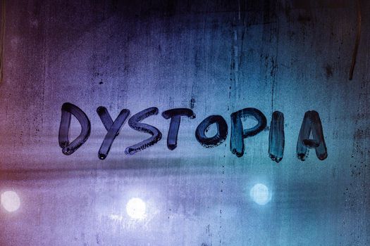 the word dystopia handwritten on wet window glass surface close-up with selective focus and color gradient