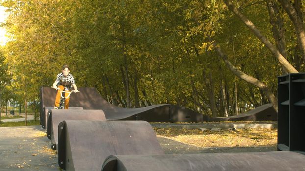 Young boy, biker riding on the pump track in the park at sunny day. Childrens sport and healthy lifestyle concept