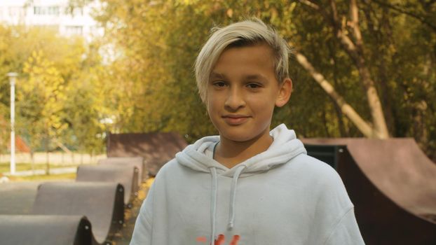 Portrait of smiling boy on the background of the park. Summer day, pump track