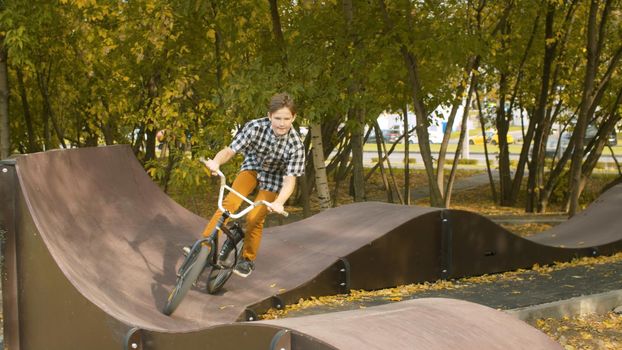 Young boy, biker riding on the pump track in the park at sunny day. Childrens sport and healthy lifestyle concept