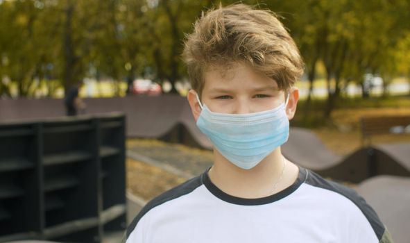 Portrait of teen boy wearing on a medical mask. Protection against a viral epidemic in the city. Health medical care and safety, flu virus, pandemic