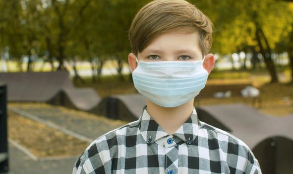 Portrait of teen boy wearing a medical mask. Protection against a viral epidemic in the city. Health medical care and safety, flu virus, pandemic