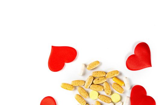 The hearts, tablets and pills isolated on white background Valentines Day or pharmaceutical background