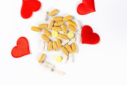 The hearts, tablets and pills isolated on white background Valentines Day or pharmaceutical background