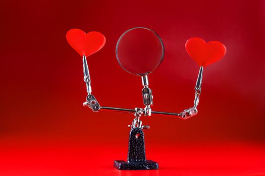 Abstract Valentines Day background with engineering tool third hand holding hearts on red background and copyspace