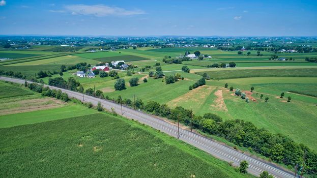 Aerial View of Multiple Farms and Train Tracks going Thru Them on a Beautiful Summer Day