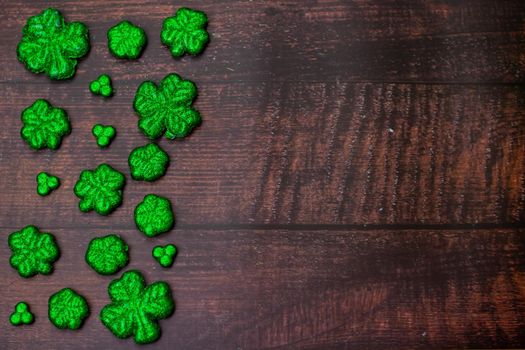 Glitter Covered Four Leaf Clovers for Saint Pattys Day Filling Half the Frame on a Wooden Background