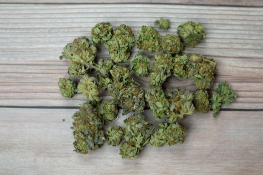 A Pile of Light Green Cannabis Nugs on a Wooden Background