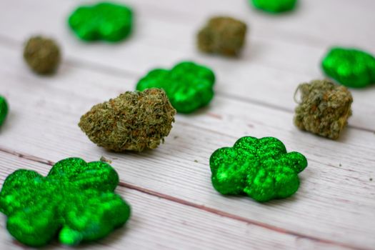 Cannabis Nugs Next to Glitter Covered Four Leaf Clovers for Saint Pattys Day