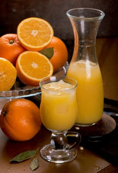 glass of fresh orange juice with fresh fruits on wooden table