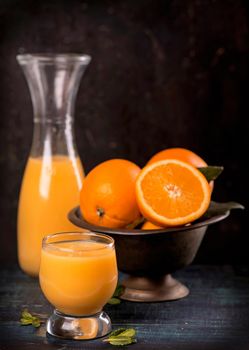 glass of fresh orange juice with fresh fruits on wooden table