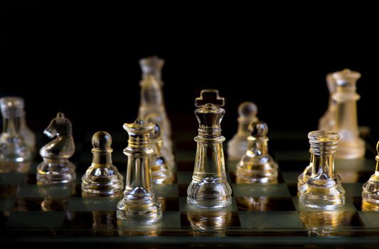 glass chess pieces on board in dark