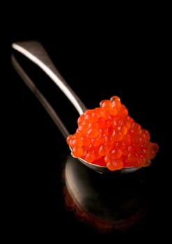 Red Caviar in a spoon. Close-up salmon caviar. Delicatessen. Gourmet food. Texture of caviar. Seafood
