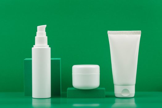 Still life with face cream or lotion, white jar with balm or mask and hands or body cream with geometric props against green background. Concept of luxury organic skincare with natural ingredients