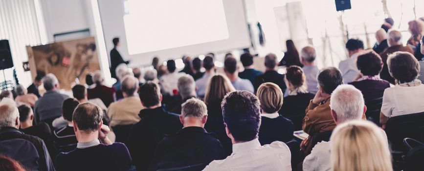 Speaker Giving a Talk at Business Meeting. Audience in the conference hall. Business and Entrepreneurship. Panoramic composition suitable for banners.