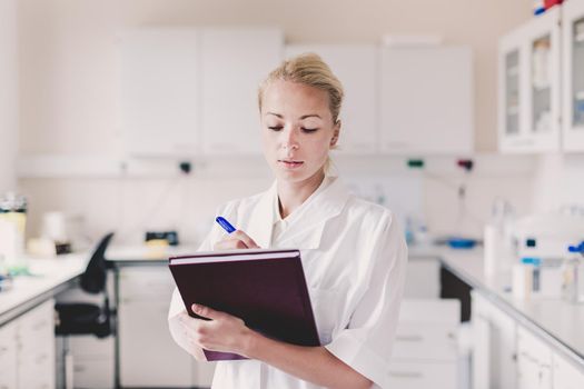 Portrait of an attractive, young, confident female health care professional in his working environment.