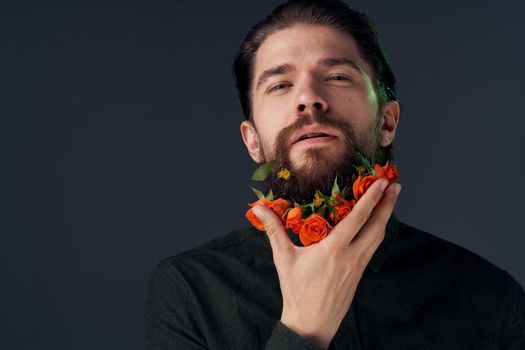 Emotional bearded man flowers romance close-up dark background. High quality photo