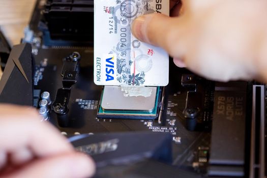 Moscow, Russia -25 Dec 2020: Applying thermal paste to the CPU of a desktop PC