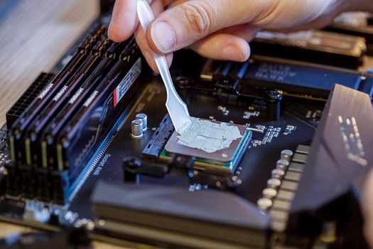 Moscow, Russia -25 Dec 2020: Applying thermal paste to the CPU of a desktop PC