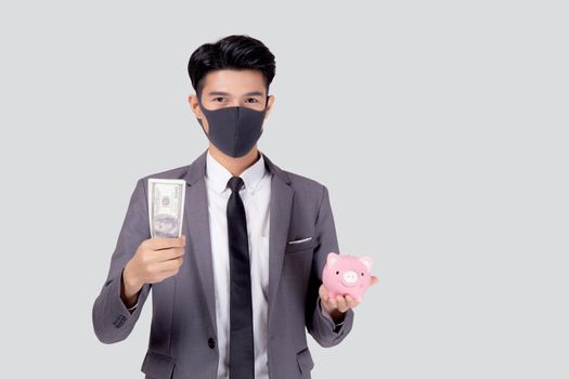 Young asian businessman in face mask holding money dollar and piggy bank isolated on white background, crisis of economic, business man in mask investment finance and saving during disease covid-19.